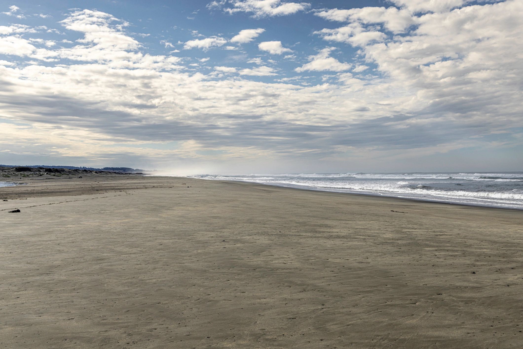 Calm, wide California beach with gentle waves and open sky